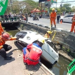 Anggota BPBD Kota Surabaya saat melakukan evakuasi mobil yang tercebur ke sungai di Jalan Arief Rahman Hakim, Sukolilo, Kamis (28/9/2023).