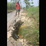 Salah seorang petani menunjukkan lubang di jalan Parengan-Montong. foto: SUWANDI/ BANGSAONLINE