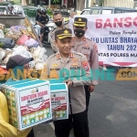 Kapolres Madiun Kota, AKBP Suryono, saat menyerahkan bantuan kepada petugas kebersihan. Foto: HENDRO SUHARTONO