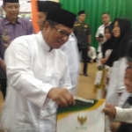 Zaini, kepala Kemenag Kota Malang saat memberikan santunan kepada seorang anak yatim. foto: Iwan/ bangsaonline.com 