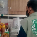 Petugas BPJS Satu saat mengunjungi Sri, seorang ibu rumah tangga yang baru saja melahirkan. (Ist)