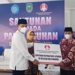 Wali Kota Maidi menyerahkan bantuan kepada Suparno Hasim, Pimpinan Darul At Taubah, salah satu panti asuhan yang ada di Kota Madiun.