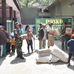 Warga antre pembagian sembako di Posko TMMD 106, Balai Desa Kedungsalam, Kec. Donomulyo, Kab. Malang.