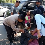 Petugas dari Polres Probolinggo Kota saat mengevakuasi keluarga korban.