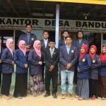 Kepala Desa Bandung, Kecamatan Konang, Kabupaten Bangkalan Mudhar (berpeci), berfoto bersama para mahasiswa di depan kantor desa yang statusnya masih kontrak itu.