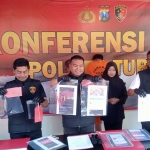 Kasatreskrim Polres Tuban AKP Dimas Robin Alexander (tengah) saat menunjukkan barang bukti dalam rilis pers ungkap kasus pengguna aktif grup Facebook Gay Tuban.