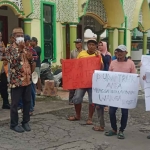 Warga Desa Delegan, Kecamatan Panceng, Gresik, saat membawa poster ketika demo jalan rusak. Foto: Ist