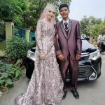Kedua pengantin muda ini tampak mesra berpose di depan mobil Toyota Camry Tahun 2021 dari ASC Foundation.