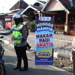 Petugas dari Satlantas Polres Mojokerto Kota saat membagikan makan gratis ke pengguna jalan.