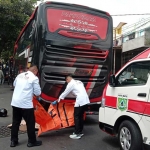 Petugas mengevakuasi korban tewas usai diseruduk bus pariwisata.