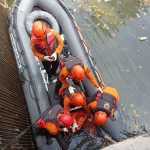 Petugas saat mengevakuasi jenazah Musrikah, lansia 82 tahun yang ditemukan tenggelam di Bozem Baratajaya Surabaya. (Ist)