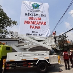 Tim Pajak Daerah BPPD Sidoarjo menutup papan reklame menunggak pajak di kawasan Kecamatan Sukodono, Selasa (29/3/2022). Foto: Ist