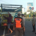 Petugas gabungan saat mengecek sebuah truk yang mengangkut hewan ternak di Simpang Tiga Mengkreng, Kabupaten Kediri. Foto: Ist