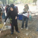 Wakil Wali Kota Kediri Lilik Muhibbah, saat memungut sampah bersama warga di kawasan obyek Wisata Goa Selomangleng. Foto: ARIF KURNIAWAN/BANGSAONLINE