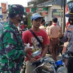 Salah seorang warga Jombang yang tidak memakai masker dihukum untuk melafalkan Pancasila. 