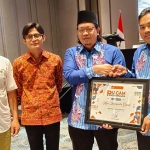 Anggota KPU Gresik, Makmun (kanan) saat menerima penghargaan. Foto: Ist