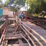Kondisi jembatan penghubung dua desa yang terbuat dari kayu dan rusak.
