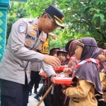 Kapolres Ngawi saat memberi paket makan siang bergizi gratis kepada salah satu siswa