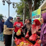 Para istri wartawan yang tergabung dalam Komunitas Wartawan Grissee ketika membagikan daging kurban kepada warga sekitar. Foto: Ist