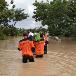 Akibat putusnya akses lalu lintas dan jalan antardesa rusak, para relawan harus berjalan kaki untuk menyalurkan bantuan sembako kepada para korban banjir. (foto: ist)