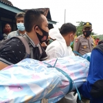 Petugas dan warga saat membantu memindahkan jenazah para korban. foto: akina nur alana/ bangsaonline.com