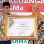 Gubernur Jatim Khofifah Indar Parawansa saat menerima penghargaan dari Menteri Desa, Pembangunan Daerah Tertinggal, dan Transmigrasi Abdul Halim Iskandar.