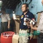 Petugas kepolisian saat menggerebek rumah yang memproduksi minuman keras ilegal di kelurahan Setono Pande Kota Kediri. foto: arif kurniawan/ BANGSAONLINE