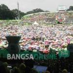 Puluhan Ribu Muslimat NU tak goyah meski panas matahari menyengat. Mereka berteduh di balik payung masing-masing di Stadion Gajayana, Malang, Jawa Timur. foto: BANGSAONLINE