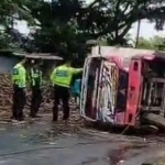 Pertugas saat membantu mengevakuasi truk dan muatan tebu yang berserakan di Jalan Purwosari, Pasuruan, Rabu (12/11/2025). 