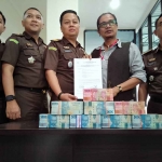 Kejari Bangkalan saat menerima uang Rp250 juta dari terdakwa korupsi dana bantuan Program Keluarga Harapan di Desa Kelbung, Kecamatan Galis.