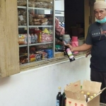 Anggota Reskrim Polsek Tlanakan saat menggeledah toko kelontong milik AB yang juga menjual minuman keras.