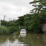 Mobil jenis Toyota Inova Nopol L 1906 ZG yang terjebak banjir di Jalan Mutiara 2.8 No. AM-1, Desa Mulung, Kecamatan Driyorejo, Gresik. Foto: Ist