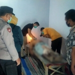 Petugas dari Polsek Pagu saat memeriksa jenazah korban gantung diri. Foto: Ist