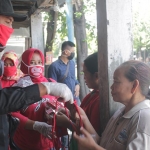 Sekretaris DPC PDIP Nganjuk Maryanto saat memberikan masker dan vitamin kepada pengunjung Pasar Bagor.
