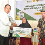 Bupati Lamongan Yuhronur Efendi saat menyerahkan bantuan secara simbolis ke warga.