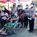 Polwan Polres Gresik saat mendampingi penyandang disabilitas jalani vaksin. foto: SYUHUD/BANGSAONLINE