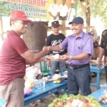 Kepala DKP Lamongan Moh Nalikan memberikan potongan tumpeng kepada Ketua LMDH Hartono.