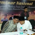 Penyair celurit emas Zawawi Imron membisiki calon wakil gubernur Jawa Timur Emil Elistianto Dardak saat acara seminar nasional bertema Masyarakat Madura Pasca Jembatan Suramadu di Sumenep Madura, Senin (2/4/2018). foto: istimewa/bangsonline.com 