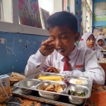 Seorang siswa di Pamekasan saat mendapat paket makanan program MBG