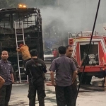 Petugas dan mobil pemadam kebakaran saat memadamkan api di Bus Kirana yang terbakar akibat Korsleting.