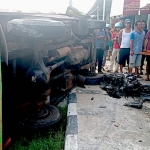 Kondisi truk yang terguling dan sepeda motor yang ringsek usai laka di Jalan Raya Merakurak-Tuban.