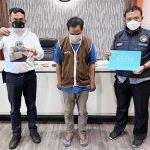 Tersangka diapit petugas Polrestabes Surabaya berikut barang bukti.