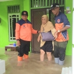 Tim BPBD Jatim saat mengevakuasi penghuni rumah yang terjebak banjir Gresik