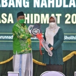 Wakil Bupati Gresik, Aminatun Habibah, saat menyerahkan kunci kepada Ketua PCNU Gresik, KH Mulyadi. Foto: SYUHUD/BANGSAONLINE
