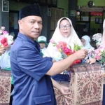 Kepala MI Labruk Kidul, Sahroni, menyerahkan bunga spesial untuk para ustazah MI dalam momen Hari Guru Nasional 2019.
