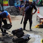 Petugas DPUPR Tulungagung saat menambal lubang di Jalan Raya Sendang. 