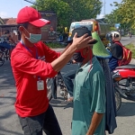 Ketua DPC PDI Perjuangan Saim, saat membagikan masker kepada salah satu pengendara motor. 