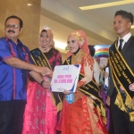 Kepala Perwakilan BKKBN Prov Jatim H Yenrizal Makmur saat menyerahkan hadiah kepada Juara 1 Duta GenRe Provinsi Jatim 2018 Jalur Pendidikan.