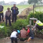 Petugas dibantu warga saat hendak mengevakuasi korban.