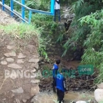 Salah satu sisi jembatan yang amblas dan jatuh ke sungai. foto: INTAN/ BANGSAONLINE